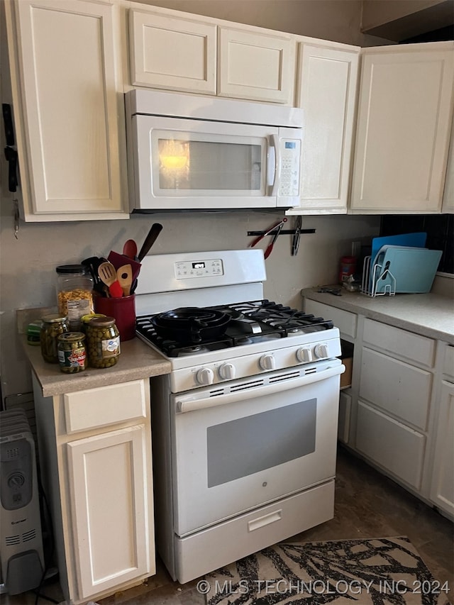 kitchen featuring white appliances and white cabinetry