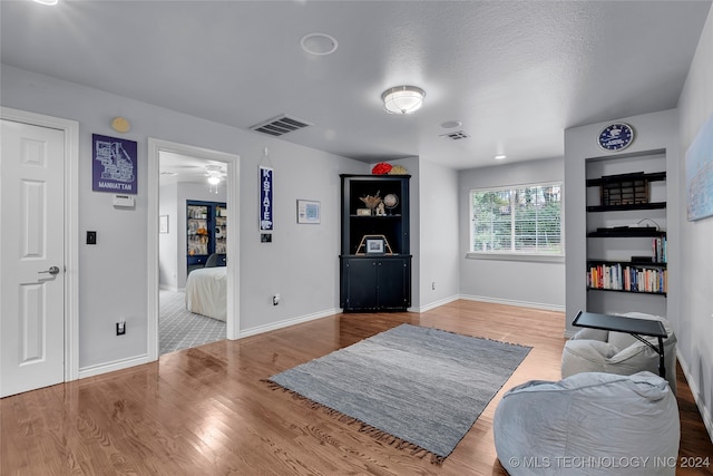 sitting room featuring ceiling fan, a textured ceiling, and hardwood / wood-style floors