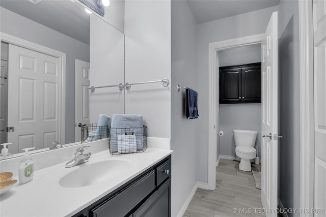 bathroom featuring hardwood / wood-style floors, vanity, and toilet