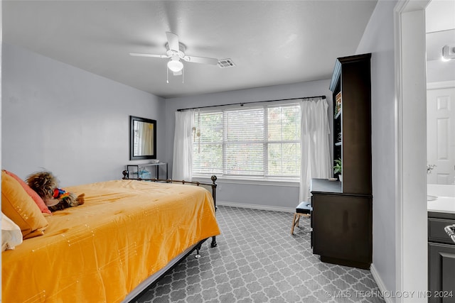 carpeted bedroom with connected bathroom and ceiling fan