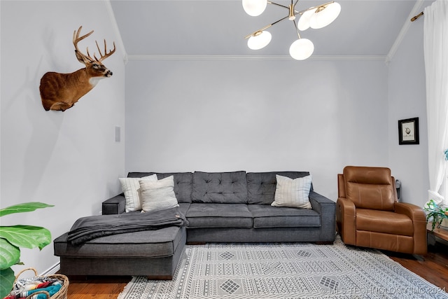 living room with ornamental molding, a notable chandelier, and hardwood / wood-style floors