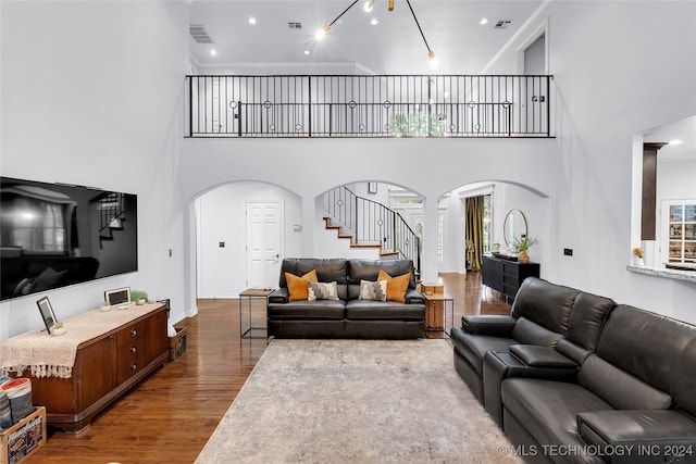 living room with a towering ceiling and hardwood / wood-style flooring