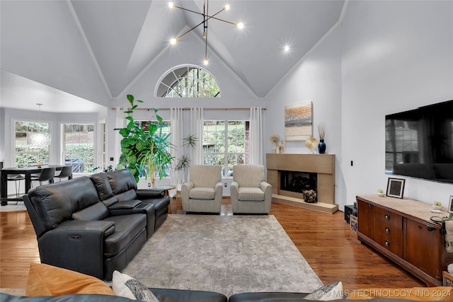 living room featuring hardwood / wood-style flooring, plenty of natural light, a high end fireplace, and high vaulted ceiling