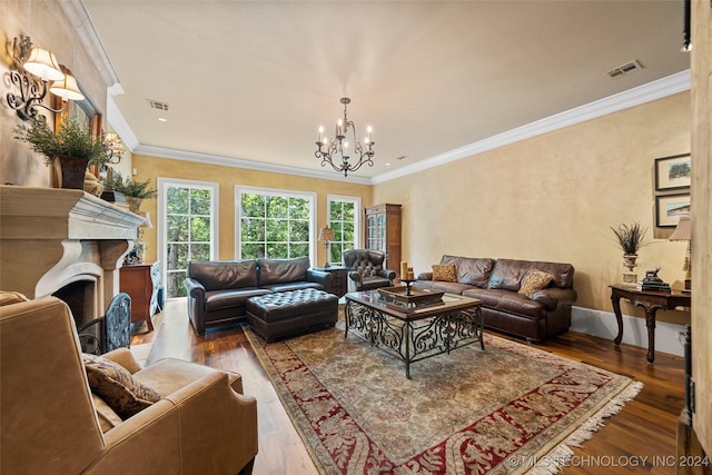 living room with ornamental molding, a notable chandelier, and hardwood / wood-style flooring