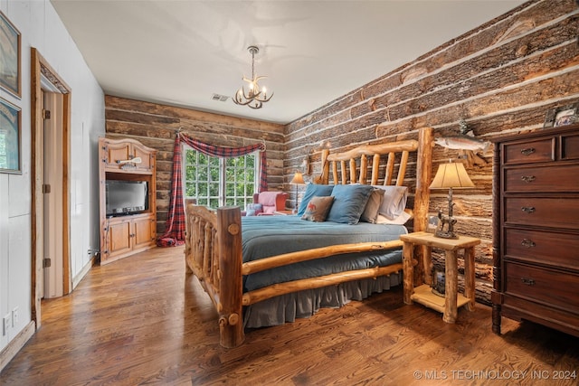 bedroom featuring log walls, wood-type flooring, and a notable chandelier