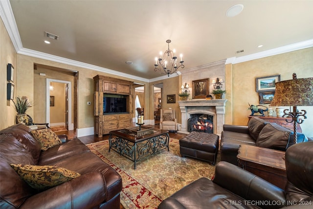 living room featuring a fireplace, wood-type flooring, an inviting chandelier, and ornamental molding