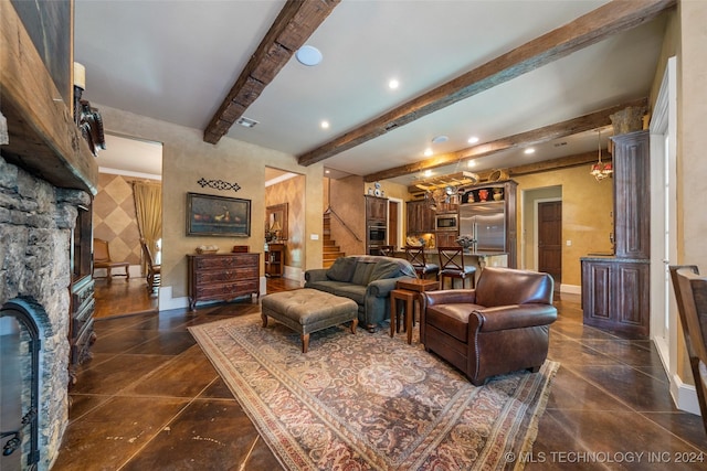 living room featuring a fireplace, ornate columns, and beamed ceiling