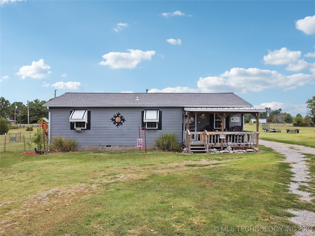 rear view of house featuring a yard