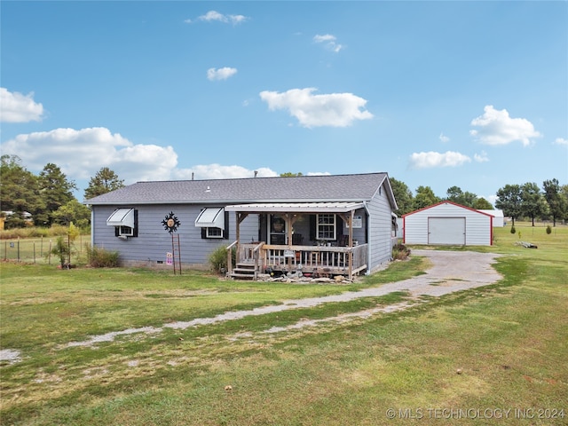 view of front facade with a front yard, an outbuilding, a garage, and covered porch