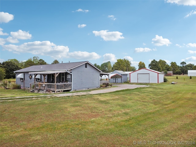 back of property with a yard, covered porch, an outbuilding, and a garage