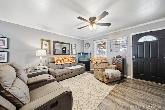 living room featuring ornamental molding, wood-type flooring, and ceiling fan