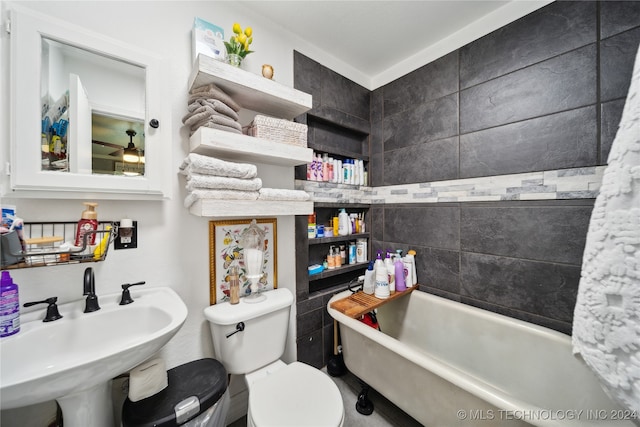 bathroom featuring toilet, a tub to relax in, and sink