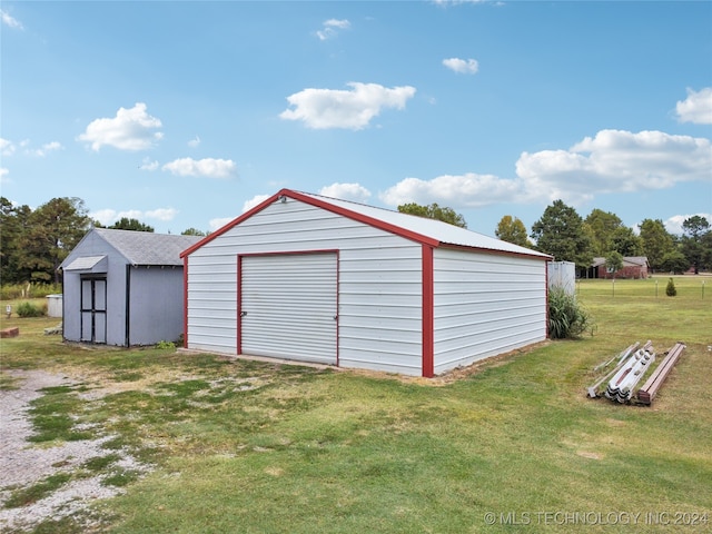 view of outdoor structure with a garage and a lawn