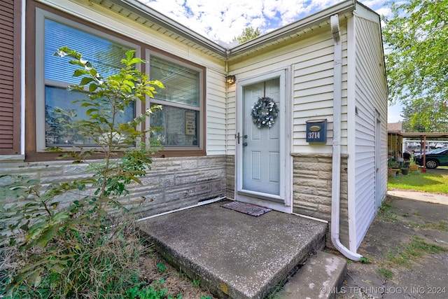 view of exterior entry with a carport