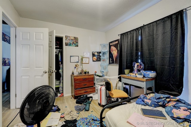 bedroom with light hardwood / wood-style floors and a textured ceiling