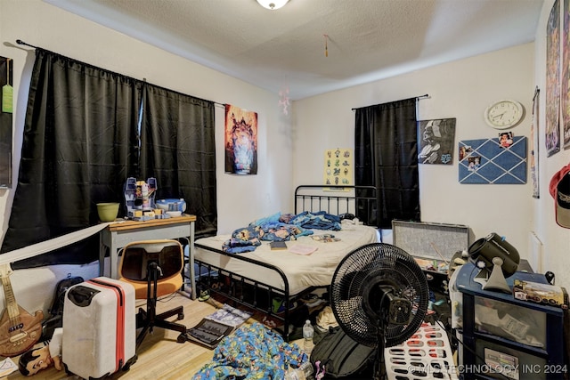 bedroom with hardwood / wood-style flooring and a textured ceiling