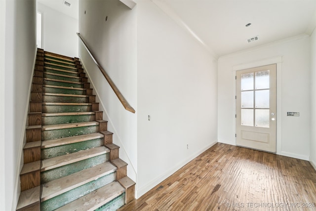 interior space with wood-type flooring and crown molding