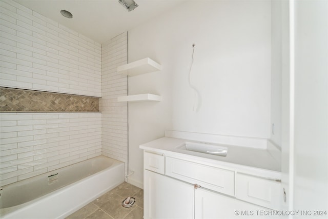 bathroom with tile patterned flooring, vanity, and tiled shower / bath combo