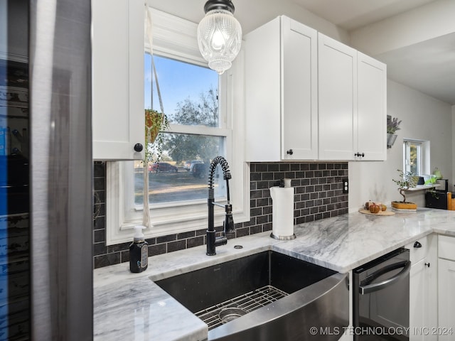 kitchen featuring light stone countertops, sink, white cabinets, and decorative backsplash