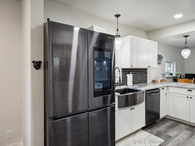 kitchen featuring white cabinetry, hanging light fixtures, stainless steel fridge, and black dishwasher