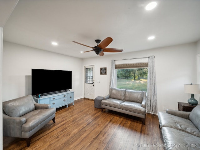 living room with ceiling fan and dark hardwood / wood-style flooring