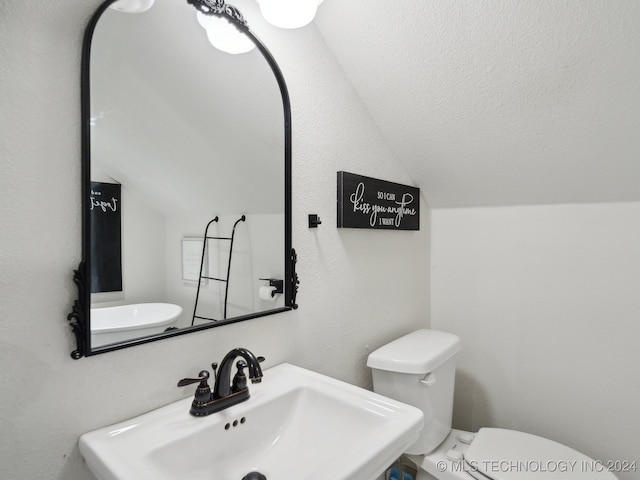 bathroom with lofted ceiling, sink, and toilet