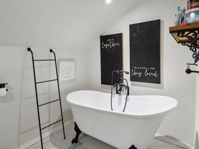 bathroom with lofted ceiling, a bath, and tile patterned floors