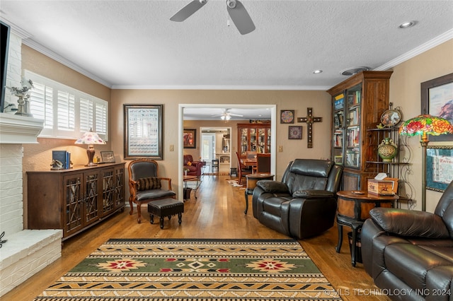 living room featuring wood-type flooring, a textured ceiling, crown molding, and ceiling fan