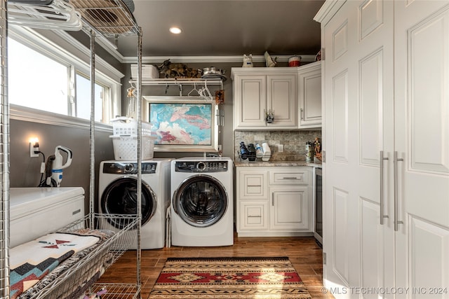 laundry area featuring separate washer and dryer, cabinets, crown molding, and dark wood-type flooring