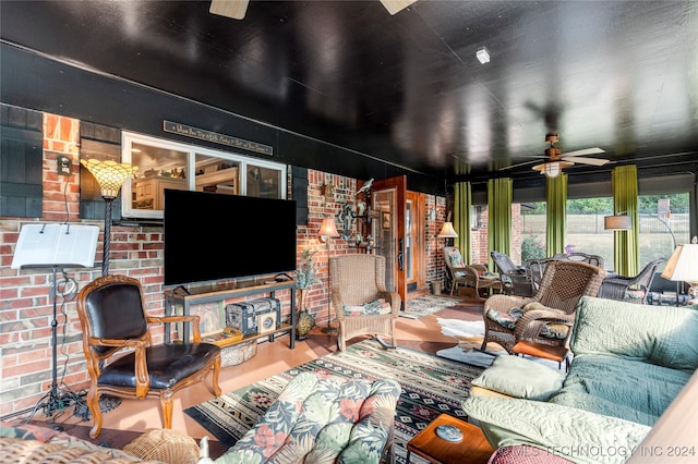 living room with ceiling fan and brick wall