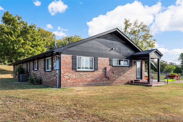 back of property featuring a yard and central air condition unit