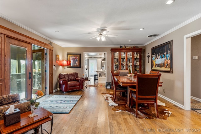 dining area featuring light wood-type flooring, ceiling fan, and crown molding