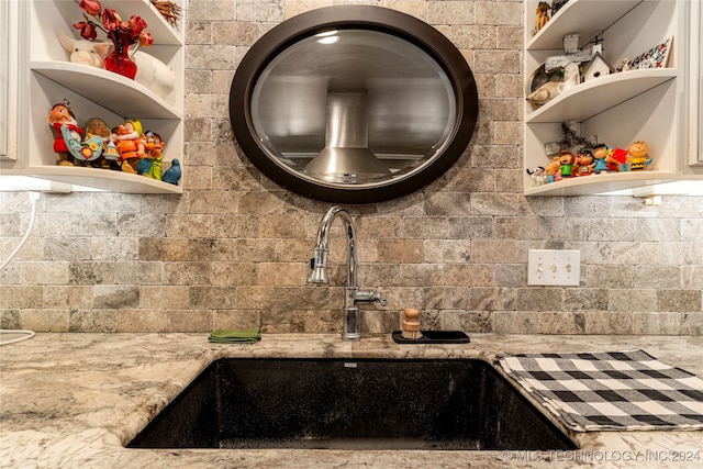 kitchen with sink, light stone counters, and tasteful backsplash