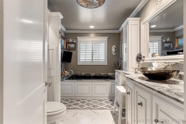 bathroom with ornamental molding, toilet, vanity, and a bathing tub