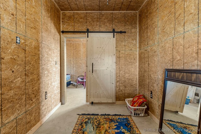 interior space featuring concrete flooring and a barn door