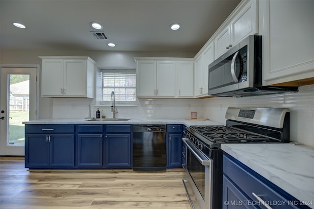 kitchen featuring appliances with stainless steel finishes, white cabinetry, blue cabinetry, light wood-type flooring, and sink