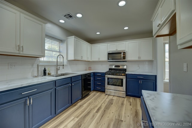 kitchen with light hardwood / wood-style floors, sink, white cabinets, stainless steel appliances, and blue cabinetry