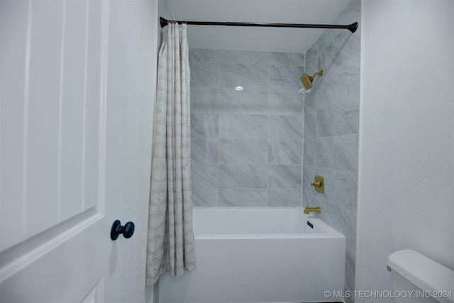 bathroom with toilet and shower / tub combo with curtain