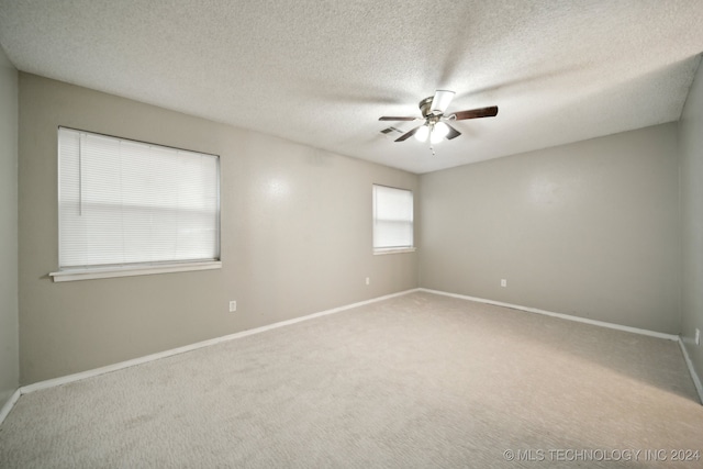 carpeted spare room with a textured ceiling and ceiling fan