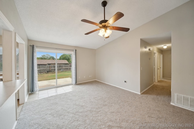 spare room with lofted ceiling, ceiling fan, light colored carpet, and a textured ceiling