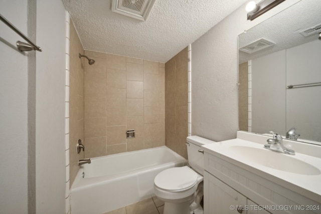 full bathroom with a textured ceiling, tiled shower / bath combo, vanity, and toilet