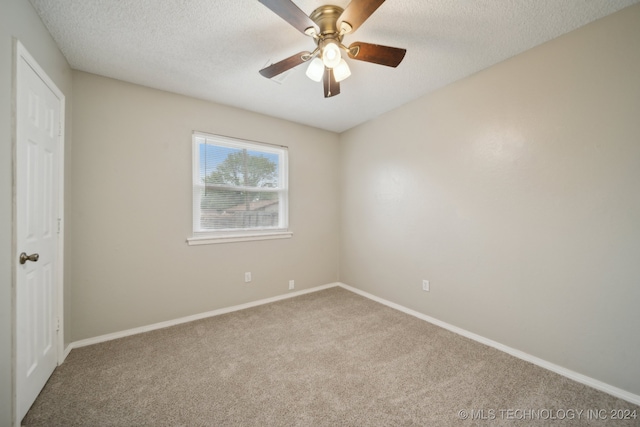 empty room featuring a textured ceiling, carpet flooring, and ceiling fan