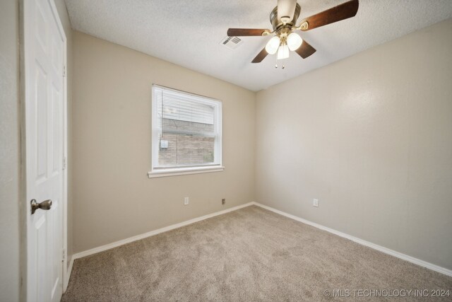 carpeted empty room with a textured ceiling and ceiling fan