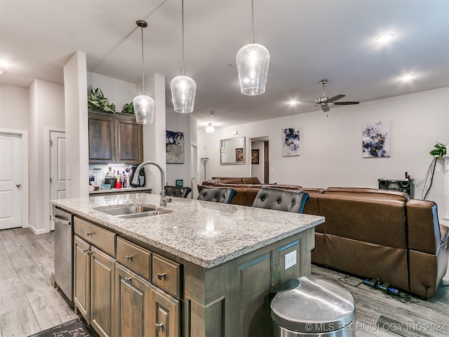 kitchen with pendant lighting, light hardwood / wood-style floors, sink, an island with sink, and ceiling fan