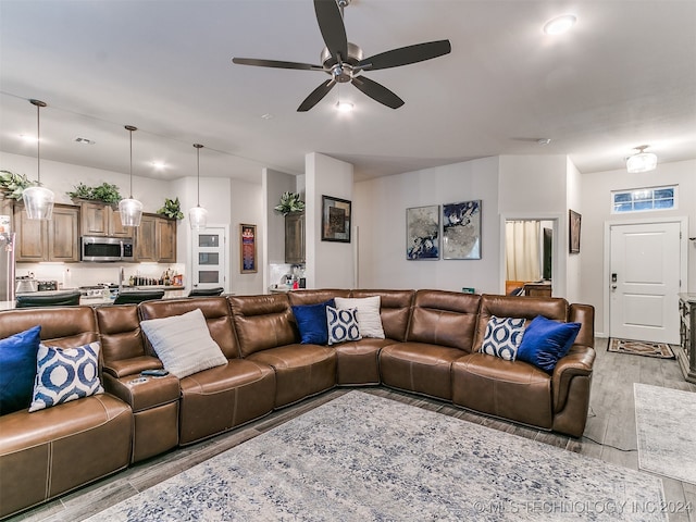 living room with light hardwood / wood-style flooring and ceiling fan