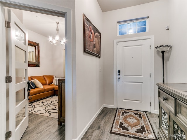 foyer with wood-type flooring and a chandelier