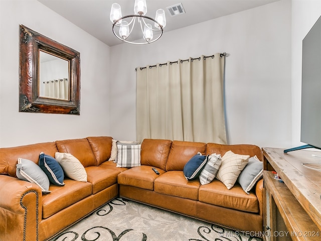 carpeted living room featuring an inviting chandelier