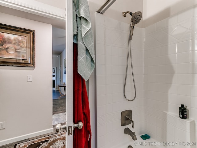 bathroom featuring a tile shower and hardwood / wood-style flooring