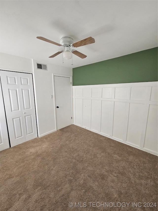 unfurnished bedroom featuring ceiling fan, carpet, and a closet