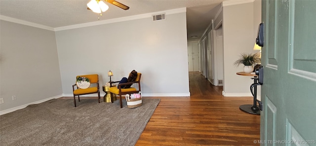 sitting room featuring a textured ceiling, ceiling fan, ornamental molding, and dark hardwood / wood-style floors